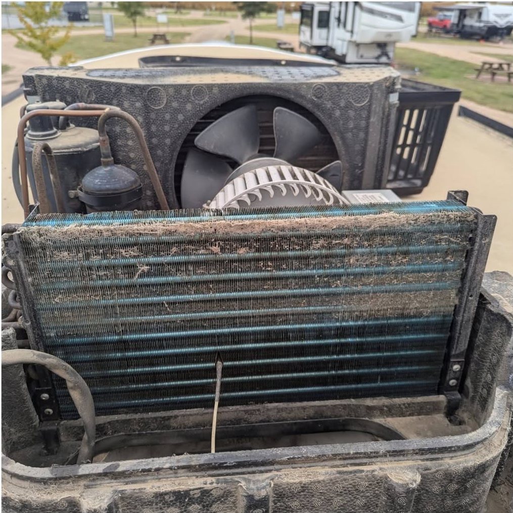 An RV A/C coil clogged with dirt before Mike cleaned it